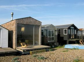 Designer Nina Tolstrup's tiny beach hut comfortably accommodates her family of four in its 388 sq ft. | www.facebook.com/SmallHouseBliss