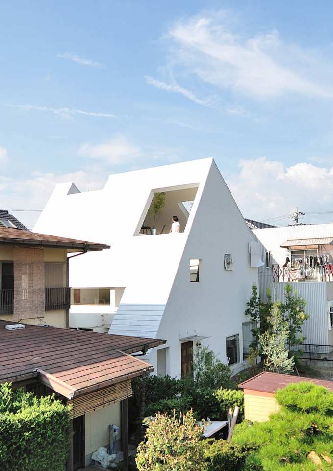 This small house for a family features terraces cut into the steeply pitched roof. | www.facebook.com/SmallHouseBliss