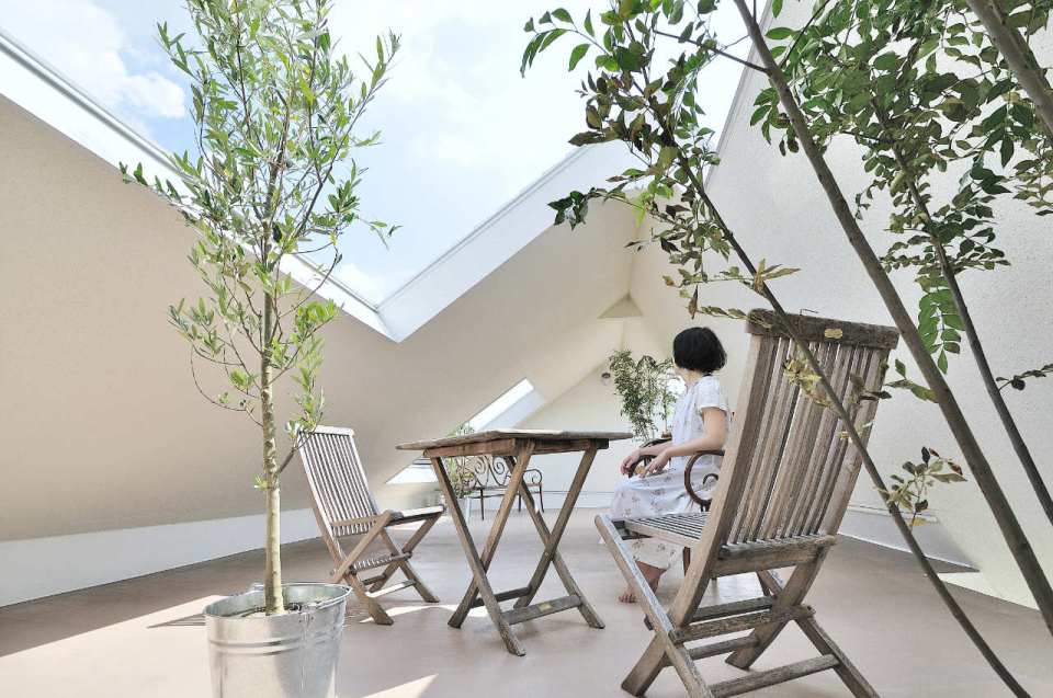 This small house for a family features terraces cut into the steeply pitched roof. | www.facebook.com/SmallHouseBliss