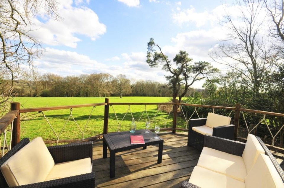A rope bridge over a pond leads to the Bensfield Treehouse, equipped with a full kitchen and bathroom. | www.facebook.com/SmallHouseBliss