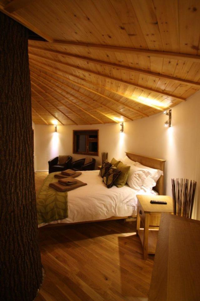 A rope bridge over a pond leads to the Bensfield Treehouse, equipped with a full kitchen and bathroom. | www.facebook.com/SmallHouseBliss