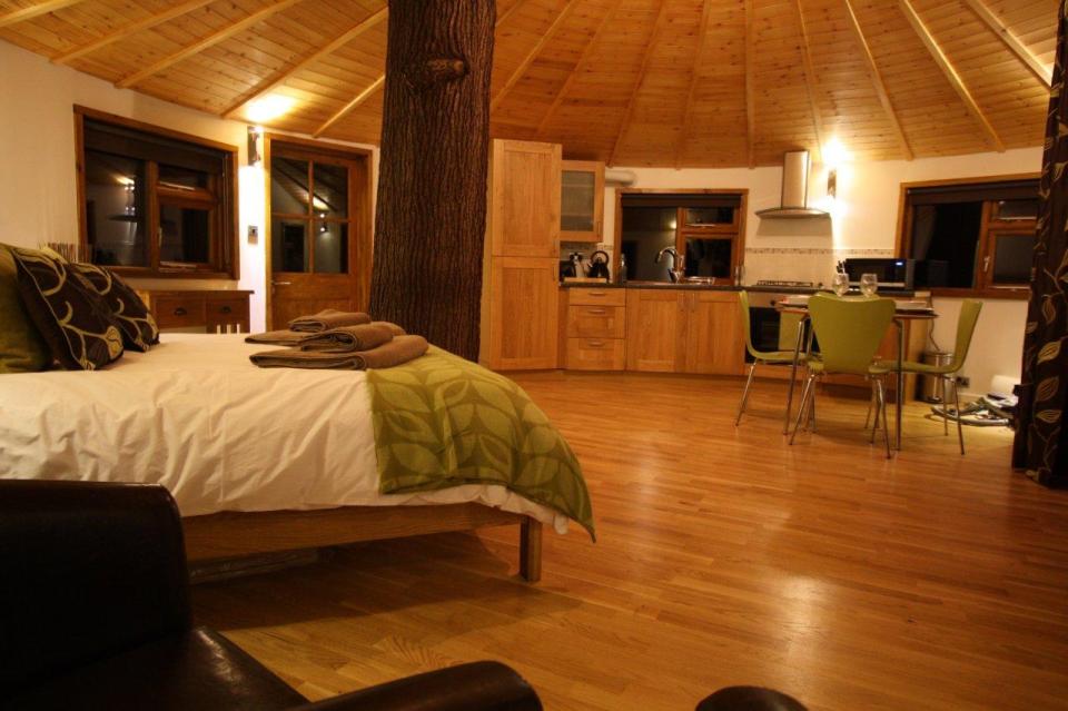 A rope bridge over a pond leads to the Bensfield Treehouse, equipped with a full kitchen and bathroom. | www.facebook.com/SmallHouseBliss