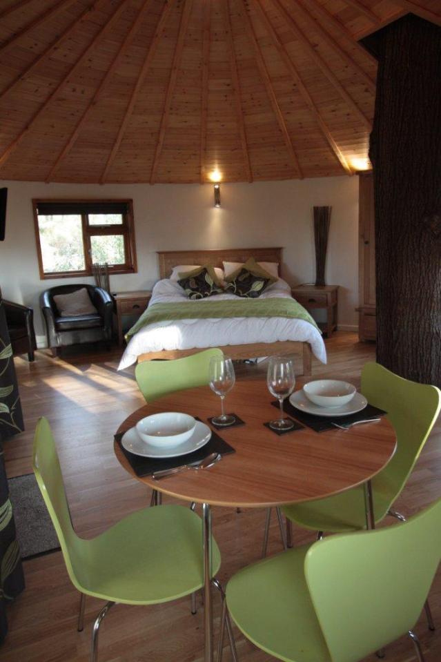 A rope bridge over a pond leads to the Bensfield Treehouse, equipped with a full kitchen and bathroom. | www.facebook.com/SmallHouseBliss