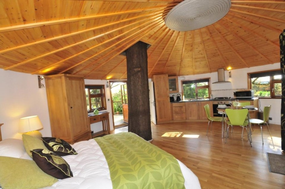 A rope bridge over a pond leads to the Bensfield Treehouse, equipped with a full kitchen and bathroom. | www.facebook.com/SmallHouseBliss