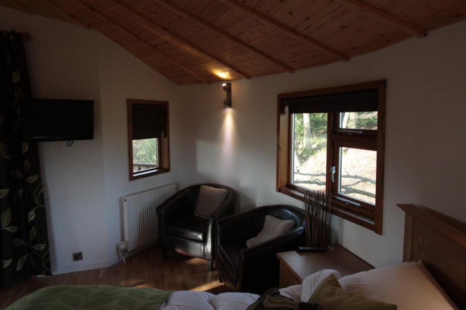 A rope bridge over a pond leads to the Bensfield Treehouse, equipped with a full kitchen and bathroom. | www.facebook.com/SmallHouseBliss