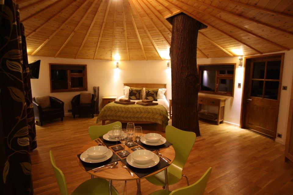 A rope bridge over a pond leads to the Bensfield Treehouse, equipped with a full kitchen and bathroom. | www.facebook.com/SmallHouseBliss