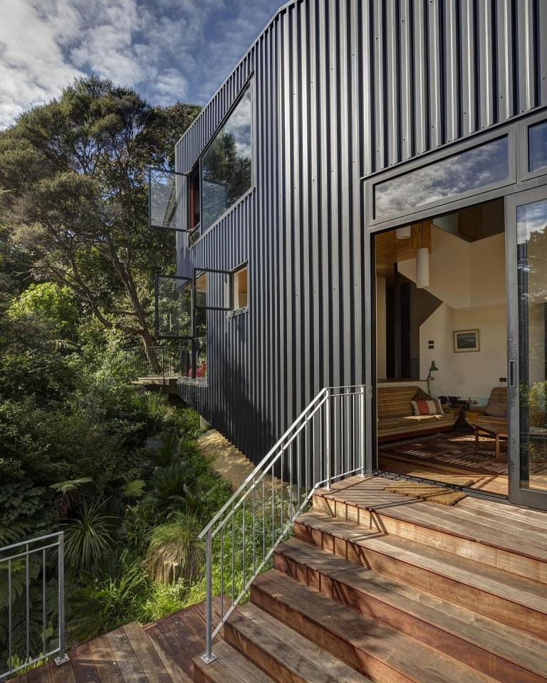 This vertically-oriented house with 1 bedroom and a small loft in 872 sq ft uses a split-level design to step down its steep site. | www.facebook.com/SmallHouseBliss