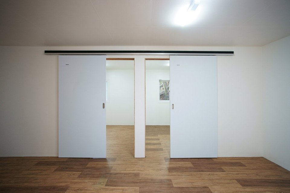 This low-cost shipping container house is covered by a tent-like polycarbonate structure to create semi-outdoor spaces between and around the containers. | www.facebook.com/SmallHouseBliss