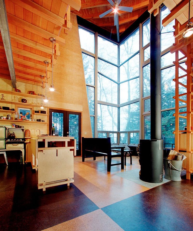 This elevated cabin features a double-height corner window. It has 800 sq ft and a pair of lofts for sleeping. | www.facebook.com/SmallHouseBliss