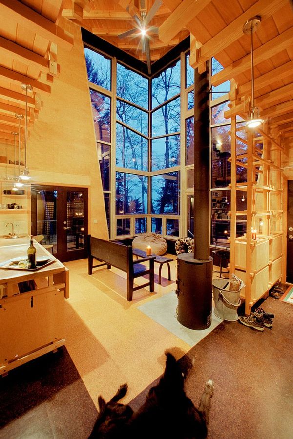 This elevated cabin features a double-height corner window. It has 800 sq ft and a pair of lofts for sleeping. | www.facebook.com/SmallHouseBliss
