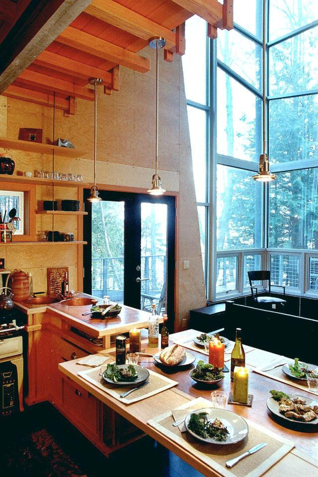This elevated cabin features a double-height corner window. It has 800 sq ft and a pair of lofts for sleeping. | www.facebook.com/SmallHouseBliss