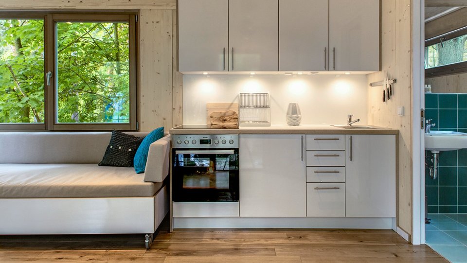 A pair of modern treehouses at the edge of a forest provide leafy retreats complete with kitchenette and bath. | www.facebook.com/SmallHouseBliss