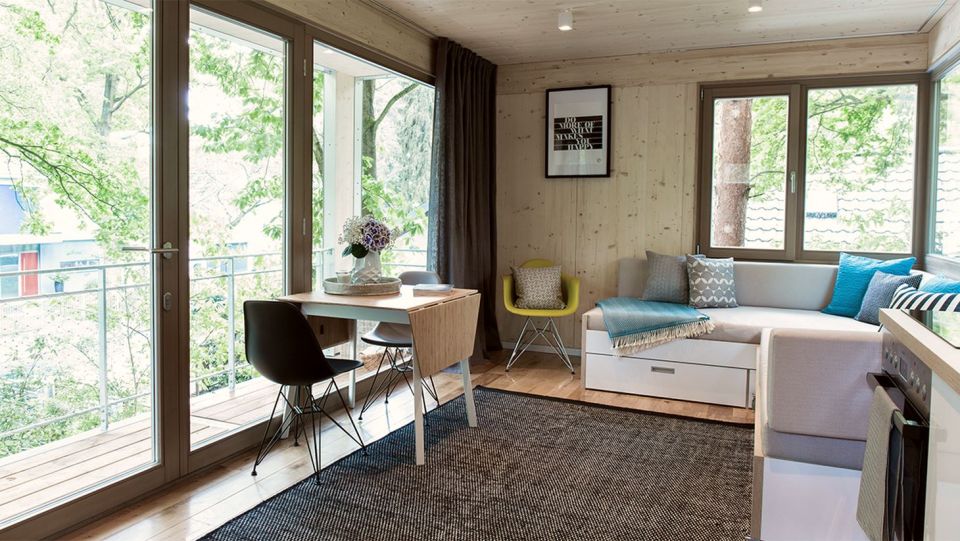 A pair of modern treehouses at the edge of a forest provide leafy retreats complete with kitchenette and bath. | www.facebook.com/SmallHouseBliss