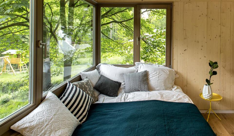 A pair of modern treehouses at the edge of a forest provide leafy retreats complete with kitchenette and bath. | www.facebook.com/SmallHouseBliss
