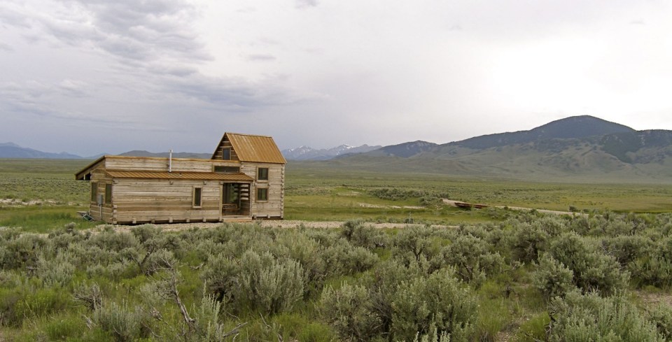 Little Lost Cabin, a small square-log cabin on 3,700 acres of Idaho ranchland. The 800 sq ft cabin has an open bedroom and a loft. | www.facebook.com/SmallHouseBliss