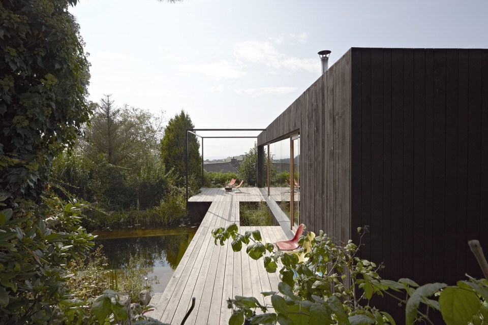 This small house sits at the edge of a pond surrounded by mature landscaping. It has one bedroom in 538 sq ft. | www.facebook.com/SmallHouseBliss
