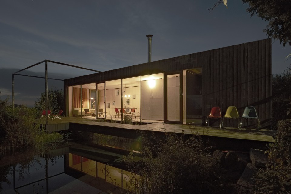 This small house sits at the edge of a pond surrounded by mature landscaping. It has one bedroom in 538 sq ft. | www.facebook.com/SmallHouseBliss