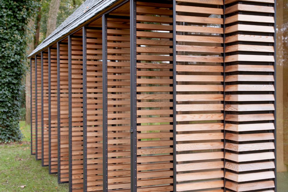 This tiny vacation cottage opens to the garden with a wall of shutters. Built-in cabinetry houses the bathroom, fireplace and kitchen. | www.facebook.com/SmallHouseBliss