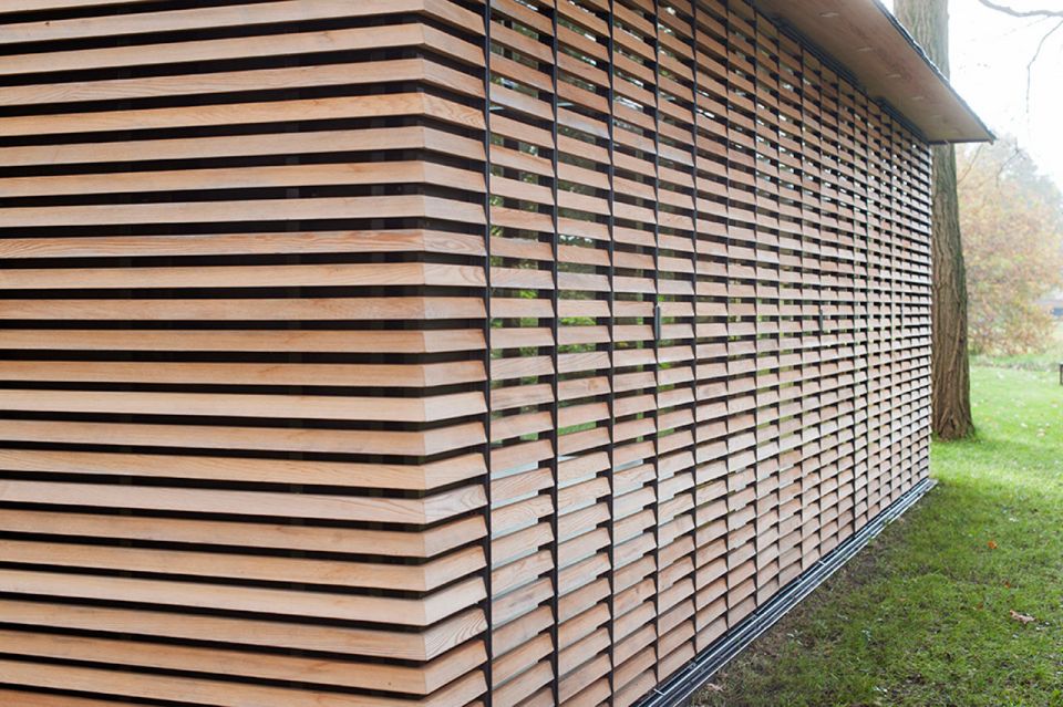 This tiny vacation cottage opens to the garden with a wall of shutters. Built-in cabinetry houses the bathroom, fireplace and kitchen. | www.facebook.com/SmallHouseBliss