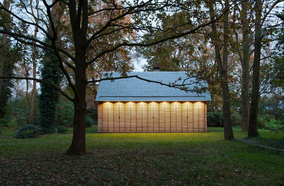 This tiny vacation cottage opens to the garden with a wall of shutters. Built-in cabinetry houses the bathroom, fireplace and kitchen. | www.facebook.com/SmallHouseBliss