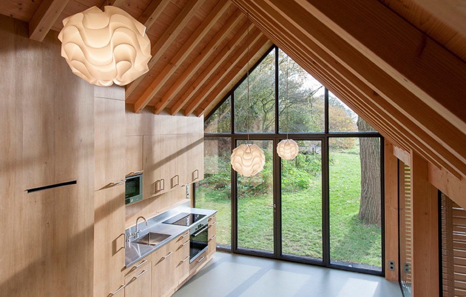 This tiny vacation cottage opens to the garden with a wall of shutters. Built-in cabinetry houses the bathroom, fireplace and kitchen. | www.facebook.com/SmallHouseBliss