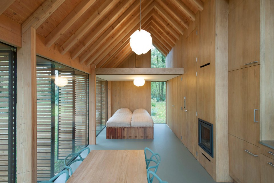 This tiny vacation cottage opens to the garden with a wall of shutters. Built-in cabinetry houses the bathroom, fireplace and kitchen. | www.facebook.com/SmallHouseBliss