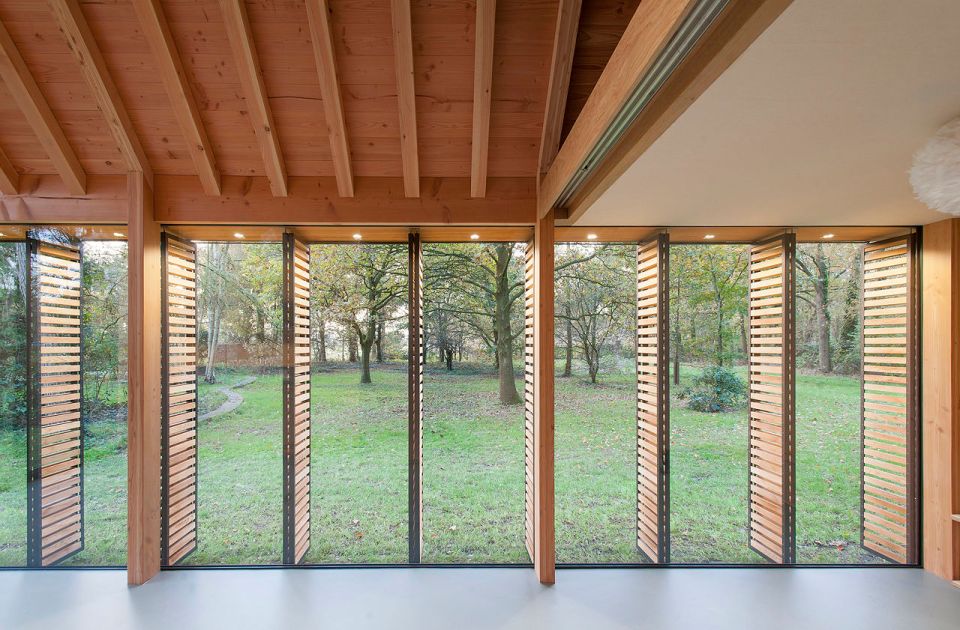 This tiny vacation cottage opens to the garden with a wall of shutters. Built-in cabinetry houses the bathroom, fireplace and kitchen. | www.facebook.com/SmallHouseBliss