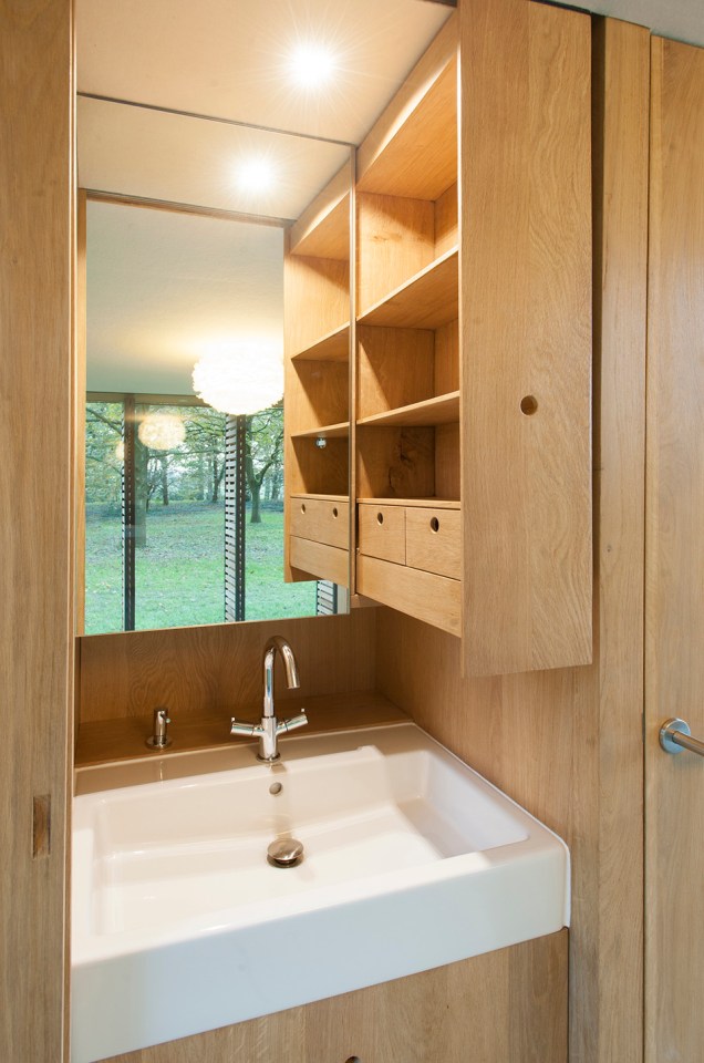 This tiny vacation cottage opens to the garden with a wall of shutters. Built-in cabinetry houses the bathroom, fireplace and kitchen. | www.facebook.com/SmallHouseBliss