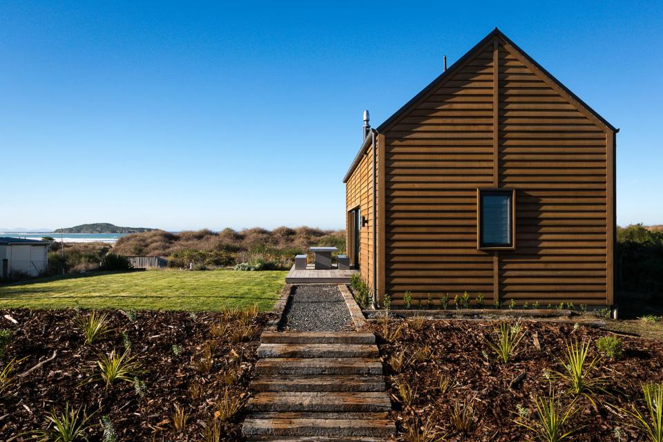 This New Zealand "bach" (a simple vacation home) has a 592 sq ft main level plus two attic loft bedrooms. | www.facebook.com/SmallHouseBliss
