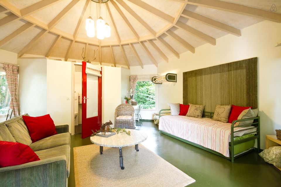 "Forest House" is a yurt-like tiny cottage with rafters radiating out from the center and an open studio floor plan. | www.facebook.com/SmallHouseBliss