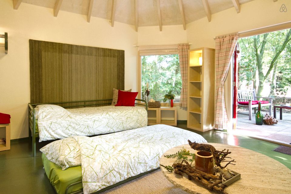 "Forest House" is a yurt-like tiny cottage with rafters radiating out from the center and an open studio floor plan. | www.facebook.com/SmallHouseBliss