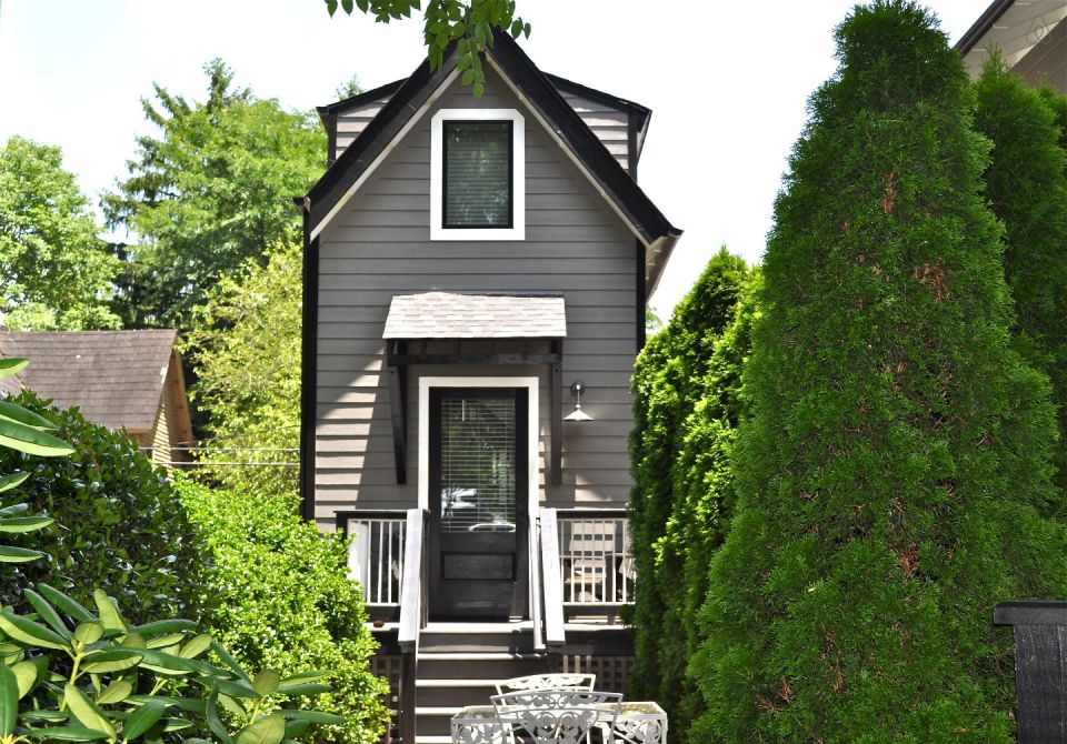 The Birdhouse, a tall and skinny tiny house with the kitchen, living room and bedroom each occupying one of the three floors. | www.facebook.com/SmallHouseBliss