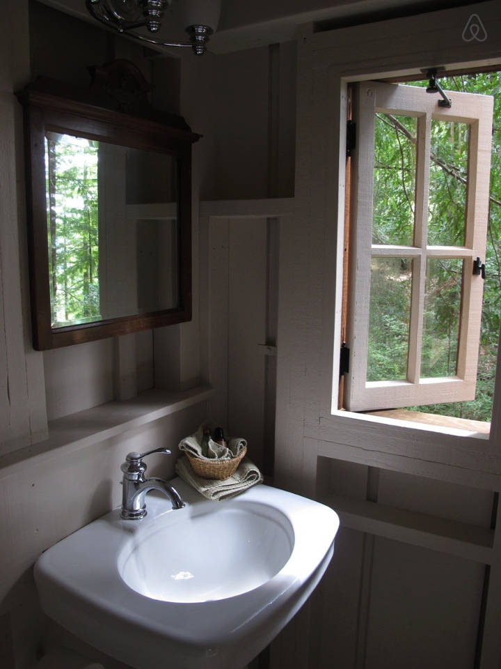 Owl Tree Cabin, a tiny cabin that feels like a treehouse. It has a compact kitchen and bathroom on the 225 sq ft main level plus a loft bedroom. | www.facebook.com/SmallHouseBliss