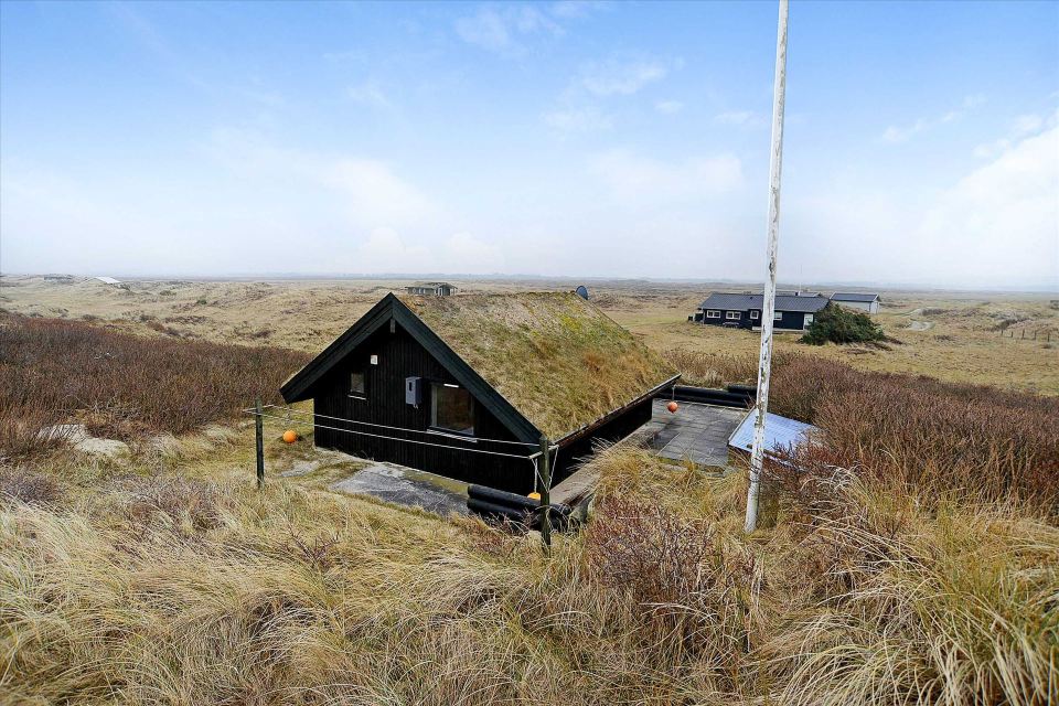 This tiny sod-roofed house sits among the sand dunes in northern Denmark. It has one bedroom in 430 sq ft. | www.facebook.com/SmallHouseBliss