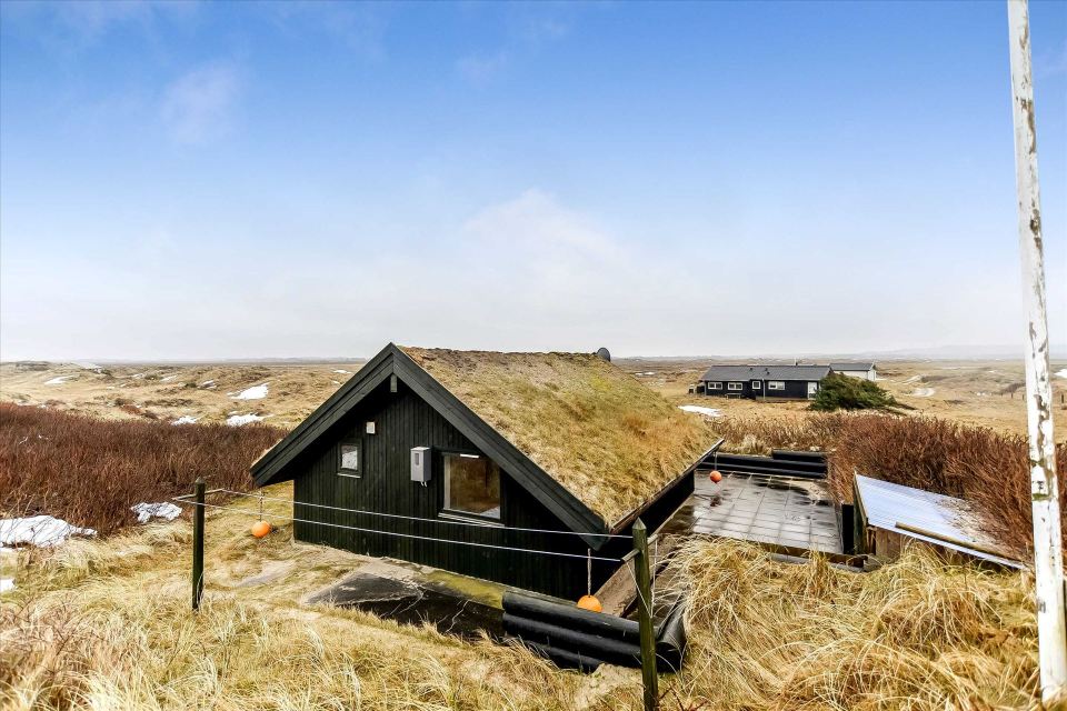 This tiny sod-roofed house sits among the sand dunes in northern Denmark. It has one bedroom in 430 sq ft. | www.facebook.com/SmallHouseBliss