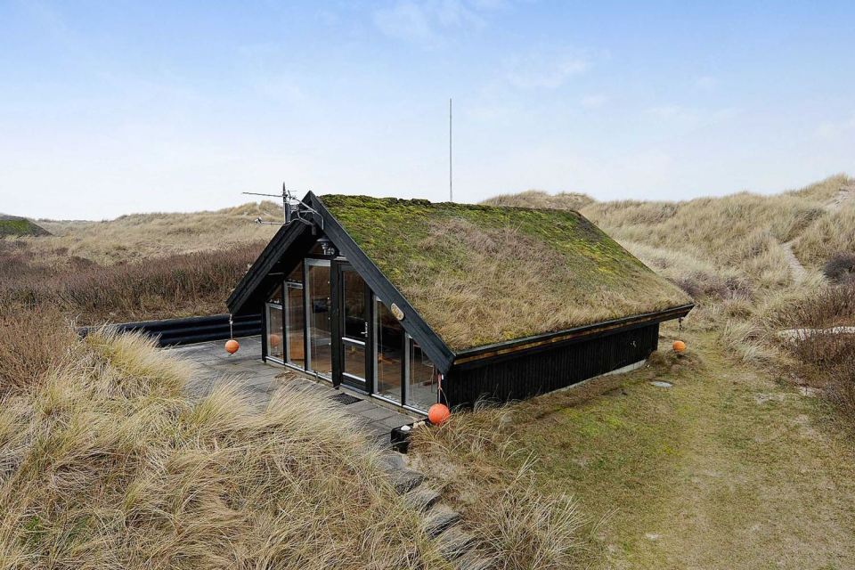 This tiny sod-roofed house sits among the sand dunes in northern Denmark. It has one bedroom in 430 sq ft. | www.facebook.com/SmallHouseBliss
