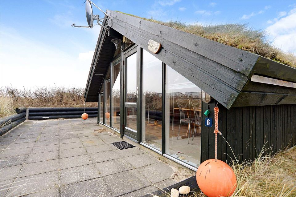 This tiny sod-roofed house sits among the sand dunes in northern Denmark. It has one bedroom in 430 sq ft. | www.facebook.com/SmallHouseBliss
