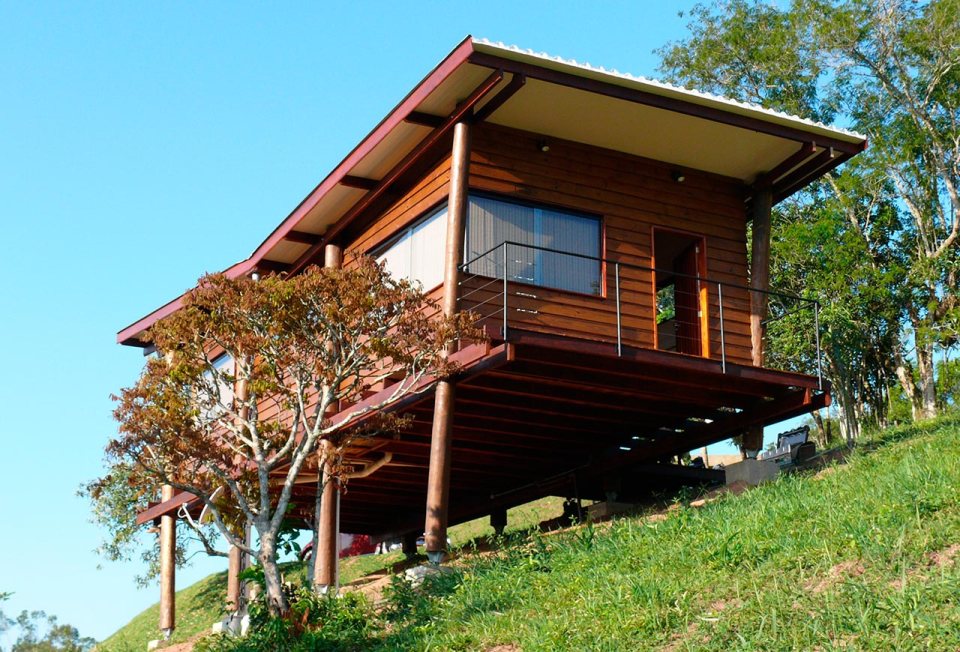 Casa em Guararema is a small wooden house in Brazil perched on eucalyptus poles. It has one bedroom in roughly 460 sq ft. | www.facebook.com/SmallHouseBliss