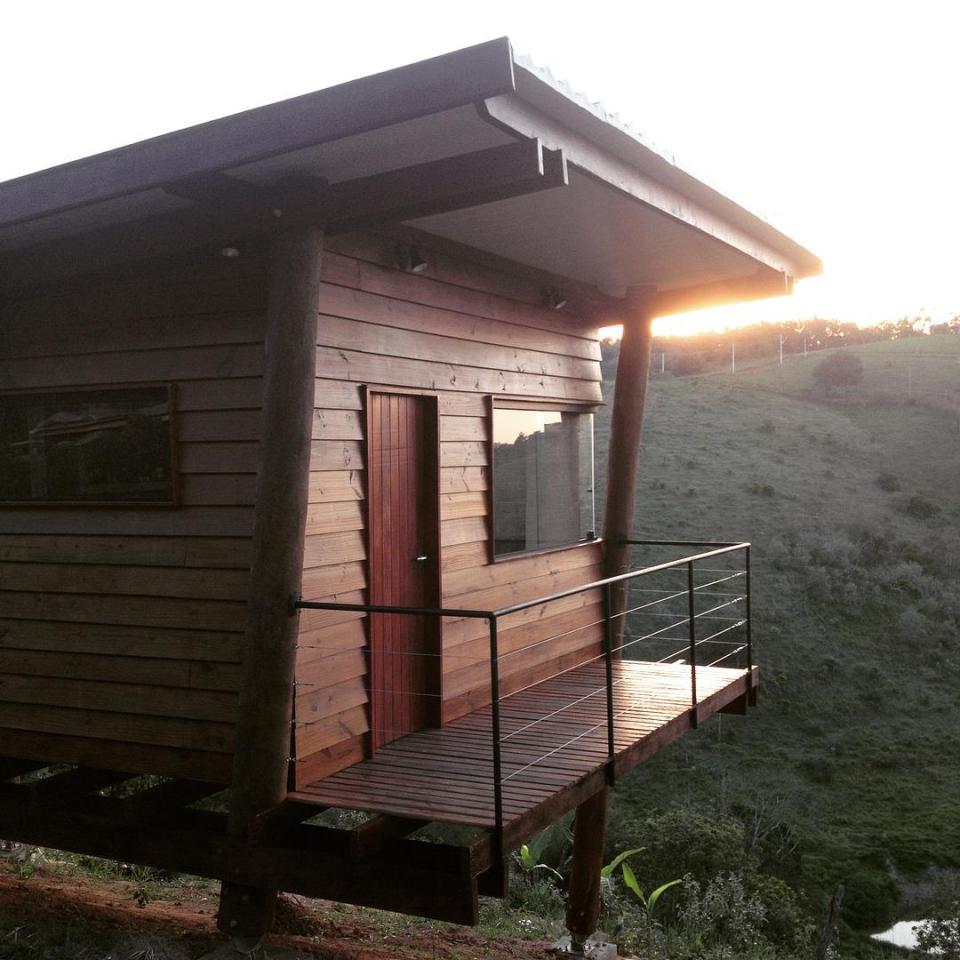 Casa em Guararema is a small wooden house in Brazil perched on eucalyptus poles. It has one bedroom in roughly 460 sq ft. | www.facebook.com/SmallHouseBliss